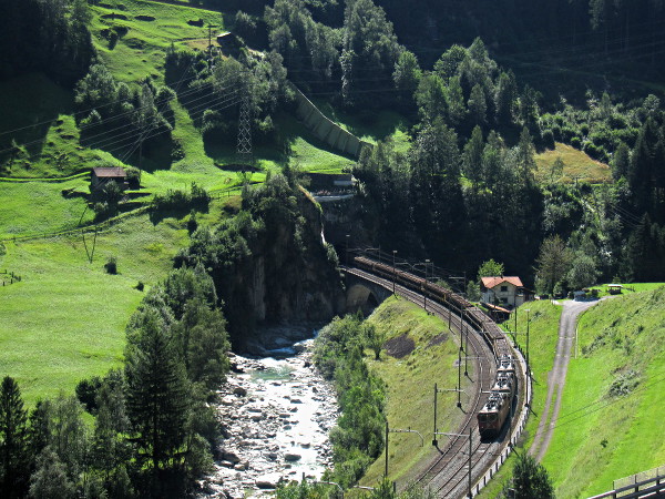 [Treno merci carico di rotaie con tripla trazione di Re 4/4 in
livrea rossa.  Il convoglio è in transito sull'Untere Wattingerbrücke
presso Wassen]