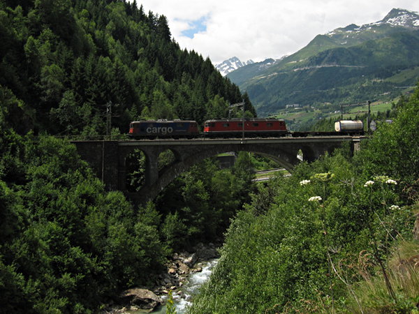 [Treno merci
trainato da Re 420 e Re 6/6 sul ponte di Stalvedro, presso Airolo.
Sullo sfondo, il passo del San Gottardo]
