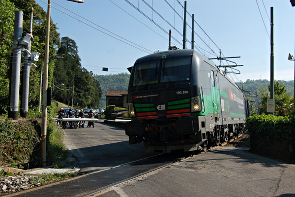 [La locomotiva 193.260, una Siemens Vectron di SBB Cargo
International, in transito sul passaggio a livello della provinciale
per Varese a Laveno (Laveno, 22 aprile 2017)]