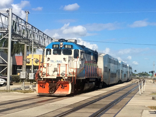 [Locomotiva diesel-elettrica EMD  GP49H-3 nº 815 di Tri-Rail
in ingresso nella stazione di Fort Lauderdale Airport alla testa di un
convoglio di carrozze a due piani Bombardier.  Dania Beach, 11 gennaio
2019.]